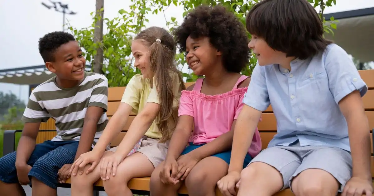 kids sitting on a buddy bench outdoors